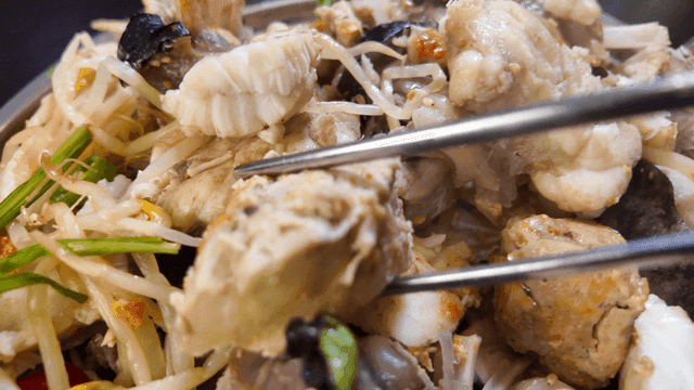 Chopsticks picking up generous portion of boiled anglerfish