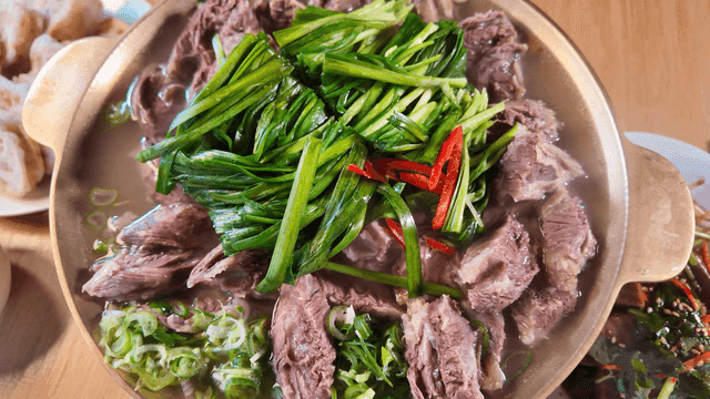 Beef short rib hot pot broth topped with plenty of steaming chives