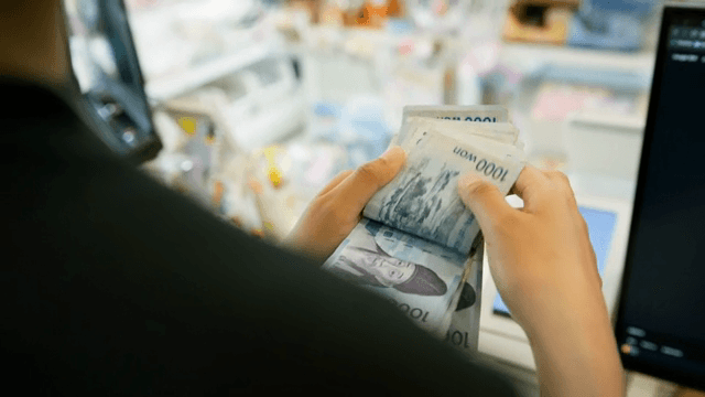 가게에서 한국 지폐를 세는 모습