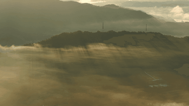 안개 낀 산 위로 햇살이 비치는 모습