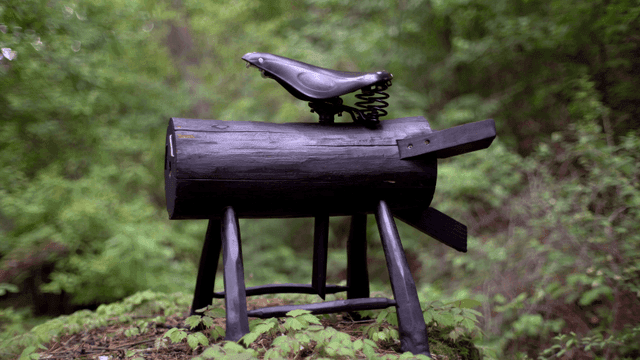 숲속 나무 위의 자전거 안장 조각상