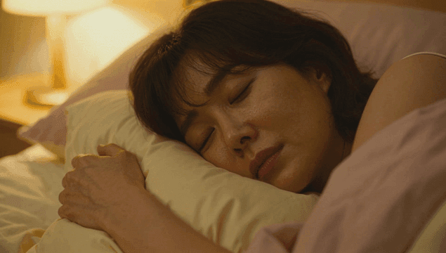 침대에서 베개를 안고 곤히 잠든 여성