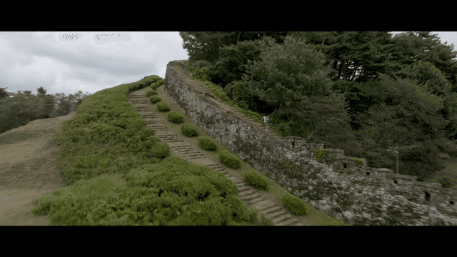 Woman walking along ancient stone wall