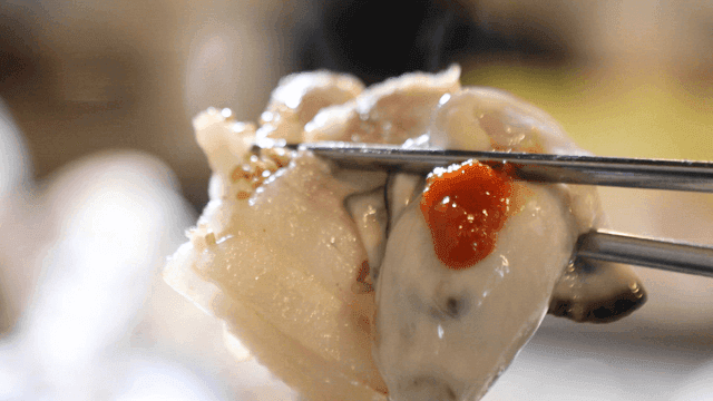 Picking up boiled pork and raw oysters with chopsticks