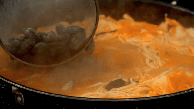 Clams in red broth noodle soup