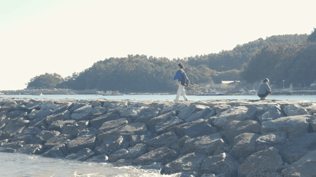 Woman walking on a rocky seaside path