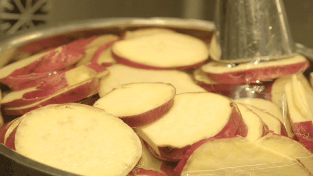 Sliced sweet potatoes soaking in water