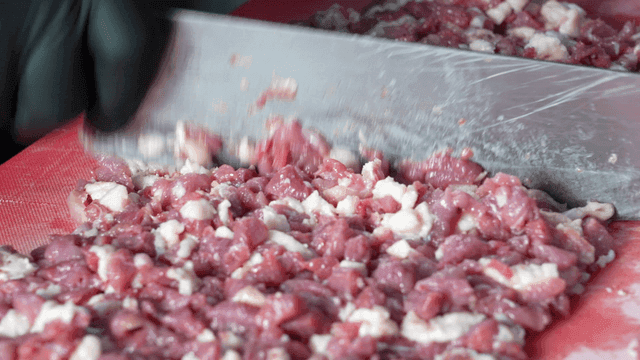 Chopping raw meat on a cutting board