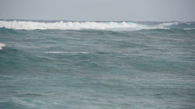 Waves crashing on a serene ocean during daytime