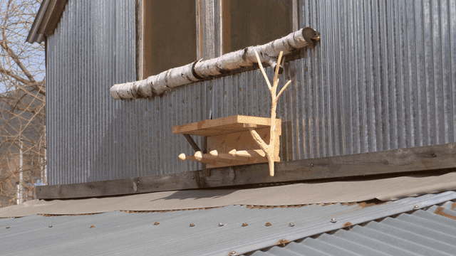 시골 집 창문 아래 놓인 나무 선반 거치대