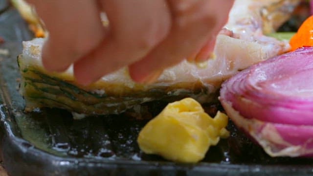 생선과 양파가 구워지는 그릴 위에서 녹는 버터