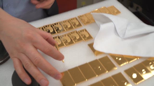 Gold plates arranged on a white surface