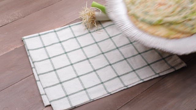 파와 함께 테이블에 놓인 노릇노릇한 파전