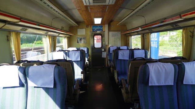 Interior of a Train Car with Empty Seats and Sunlight