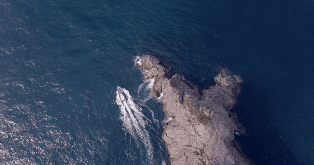 A boat navigating around a rocky island