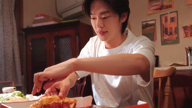 실내에서 피자를 즐기는 젊은 남성