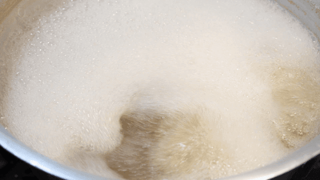 A pot of boiling liquid with foam