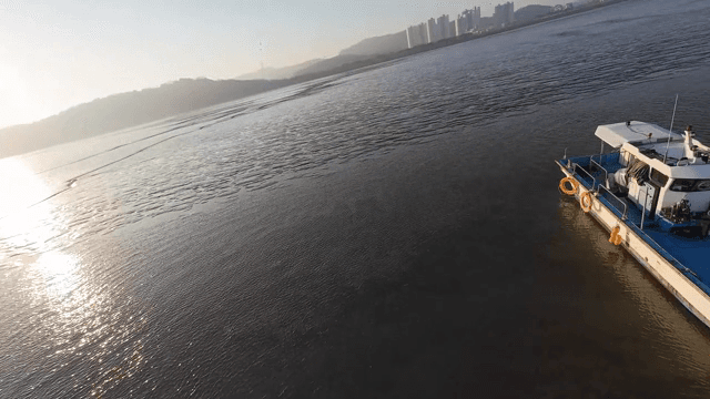 Boats floating on a calm sea at sunset