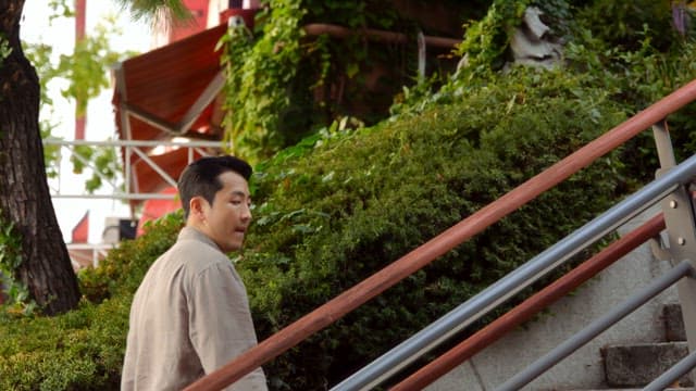 Man walking up outdoor stairs surrounded by greenery