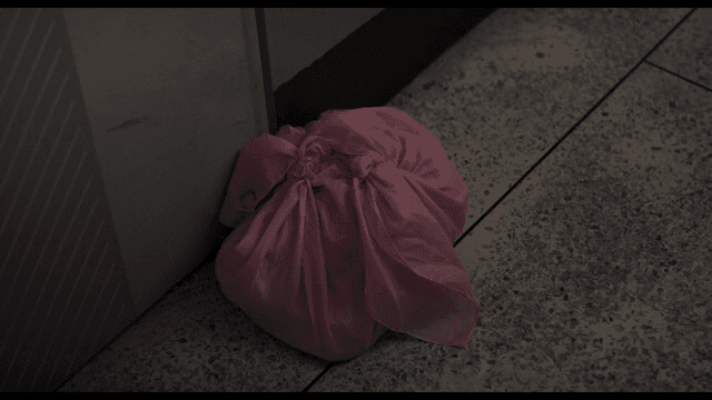 타일 바닥에 놓인 분홍색 천 보따리