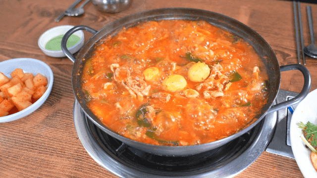 Spicy chicken offal soup simmering with side dishes