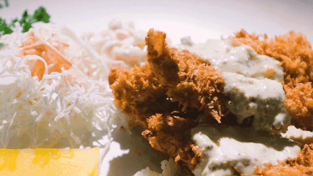 Plate with salad, pickled radish, and fish cutlet