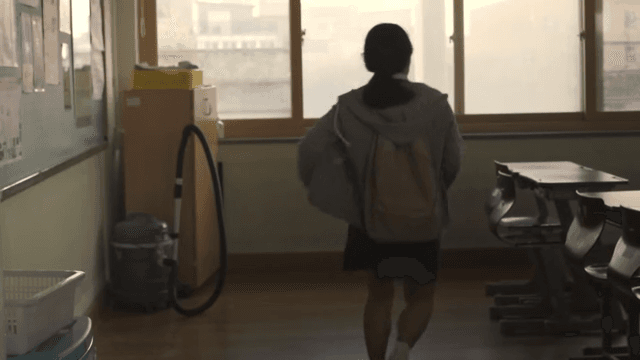 Female student entering an empty classroom in the morning