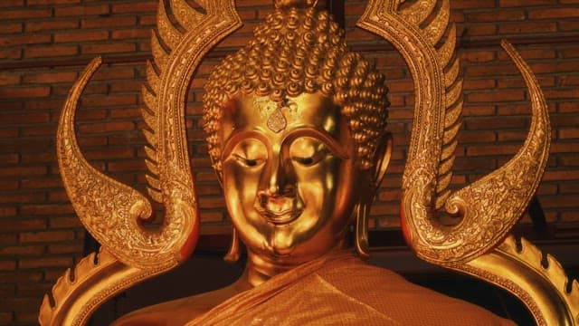 The face of a golden Buddha with a kind smile