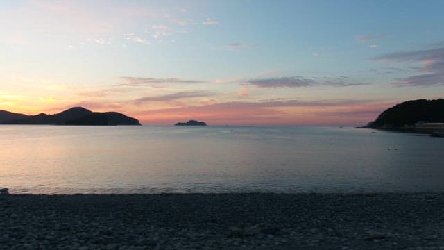 Serene Sunset at a Pebble Beach with Islands