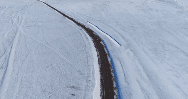 Snowy road stretching through a vast landscape