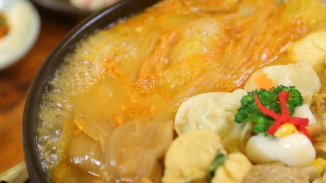 Braised aged kimchi and pork with dumplings and vegetables