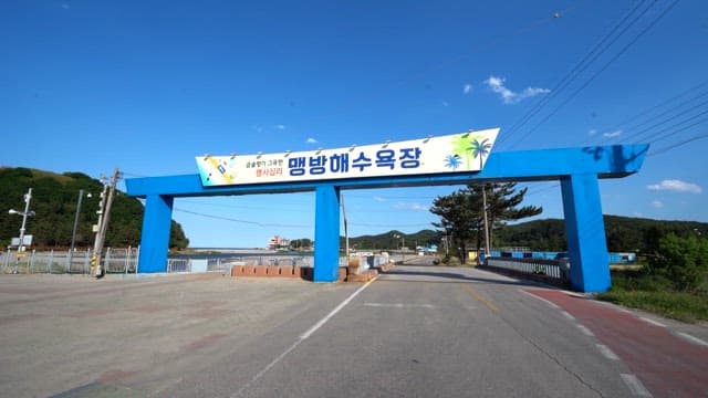 Road leading to a beach with a welcoming entrance on a sunny day