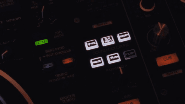Close-up of a DJ mixer with glowing buttons