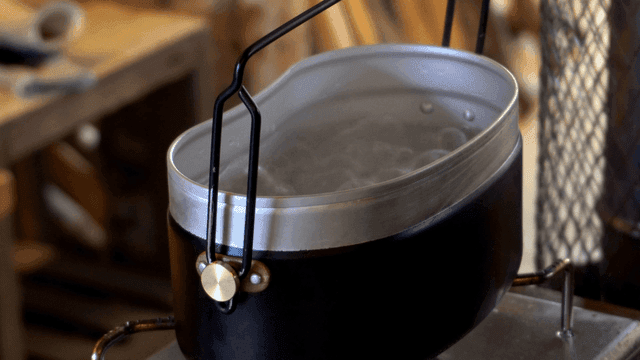 작업실 스토브 위에서 물이 끓는 반합