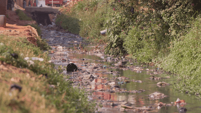 Polluted stream flowing through a village