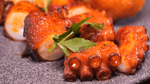 Grilled octopus with herbs on a plate