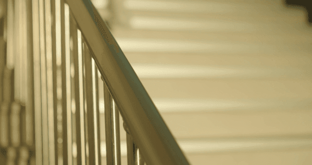 Two schoolgirls running down holding the school stair railing