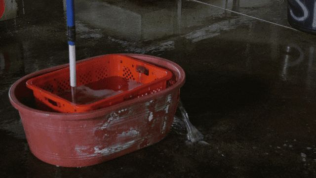 Basin placed on wet floor where water drains