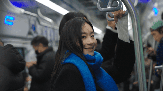 Woman smiling on a crowded subway