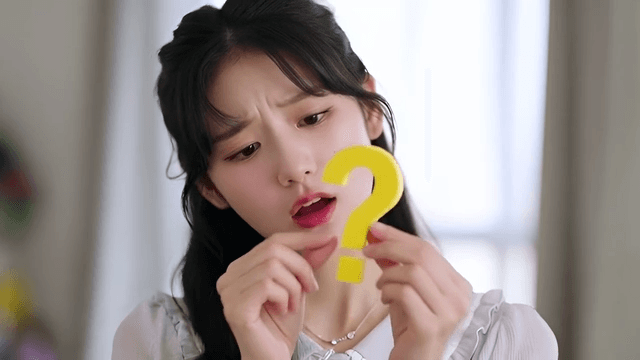 노란색 물음표를 들고 있는 젊은 여성