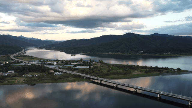 Scenic river with bridges and mountains.