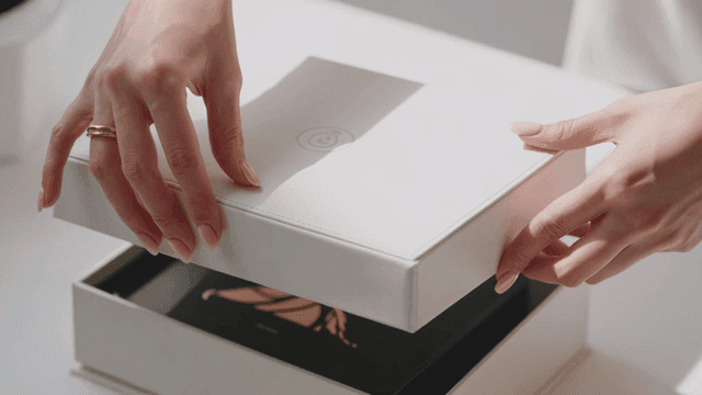 Hands opening luxurious white box