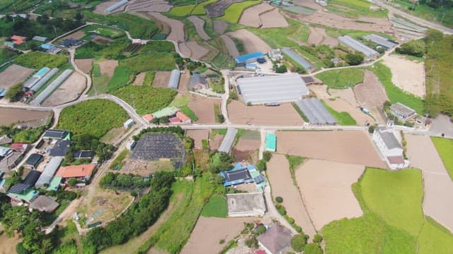 Expansive rural farmland with greenhouses