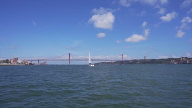 Scenery of a Yacht and Suspension Bridge on a River on a Sunny Day