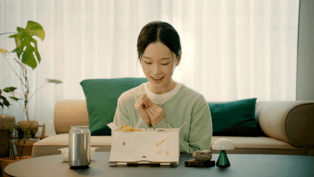 Woman smiling at sight of chicken at home