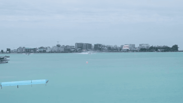 Seaplane taking off near a coastal village