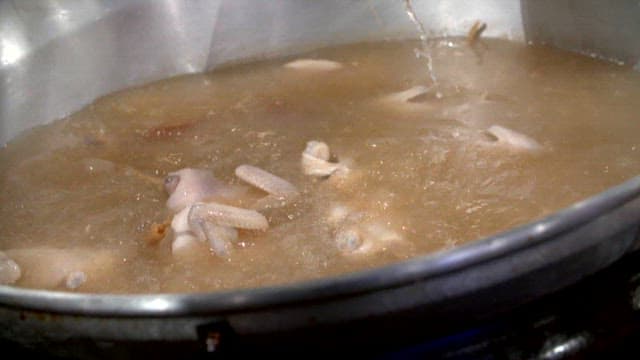 Chickens being boiled in a large pot