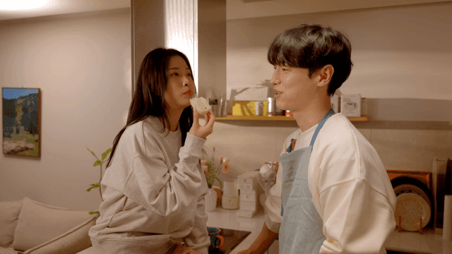 부엌에서 빵을 나눠먹으며 대화하는 행복한 커플