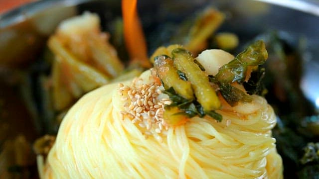 Pouring red seasoning on noodles with yeolmu kimchi