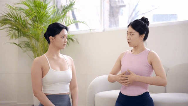 Pilates instructor guiding a student indoors